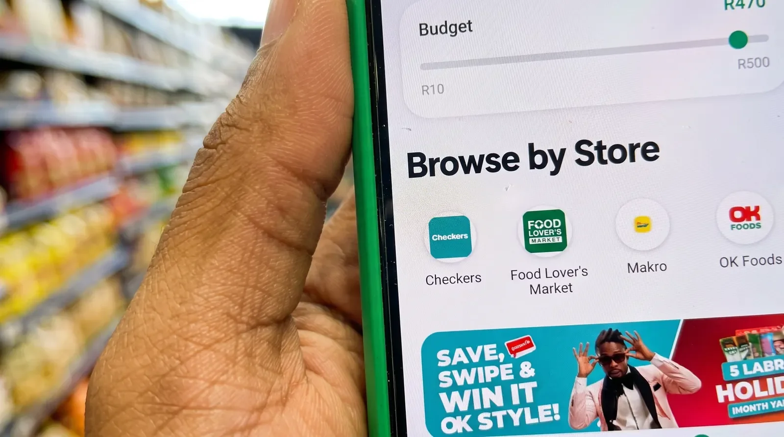 The Groza app open in a supermarket aisle, showing a budget slider and store browser